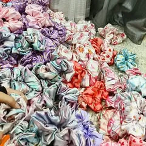 A pile of handmade satin scrunchies in many colours